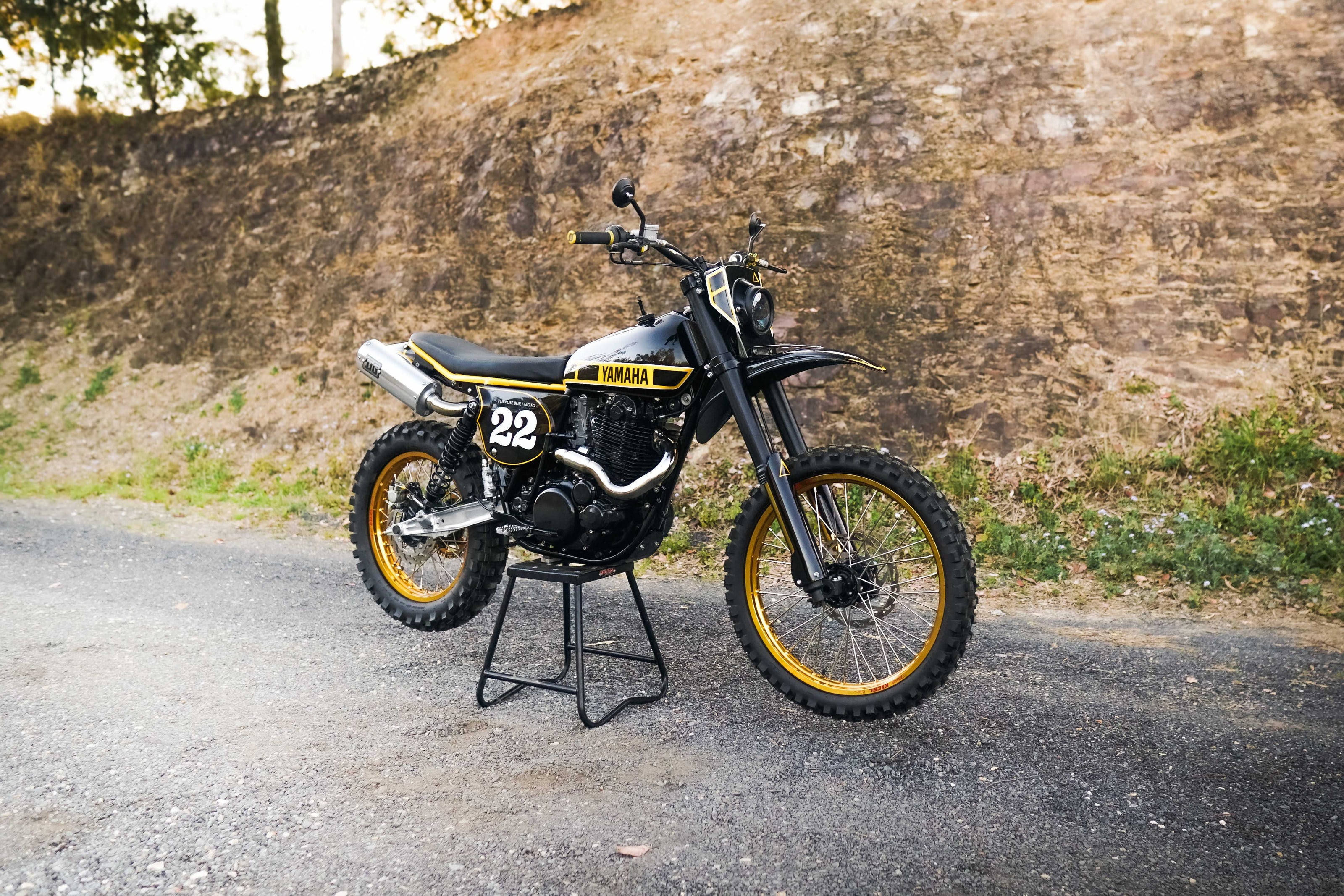 Yamaha motorcycle on a stand against a stone wall background